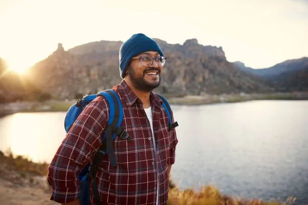 Man in a checkered shirt and green beanie taking a candid photo for good dating profile photo
